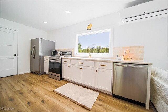 4043 Township Road 271, Killbuck, OH 44637 - kitchen featuring stainless steel appliances, a wall mounted air conditioner, a sink, light wood finished floors, and decorative backsplash