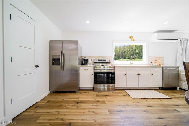 4043 Township Road 271, Killbuck, OH 44637 - kitchen featuring stainless steel appliances, an AC wall unit, backsplash, light wood-style flooring, and recessed lighting