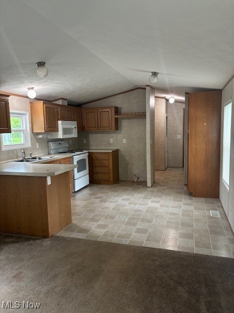 14 Carpenter Blvd, Marshallville, OH 44645 - kitchen featuring white appliances, a sink, a peninsula, light countertops, and vaulted ceiling