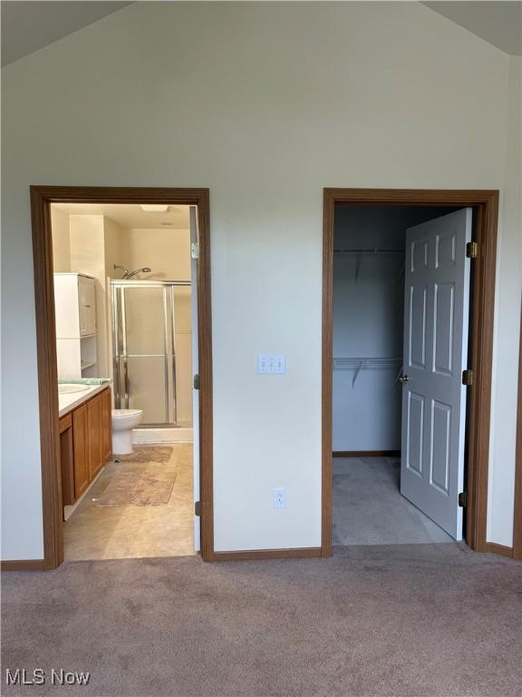1932 S Lincoln Ave Unit 2, Salem, OH 44460 - unfurnished bedroom featuring lofted ceiling, light colored carpet, a spacious closet, a closet, and baseboards