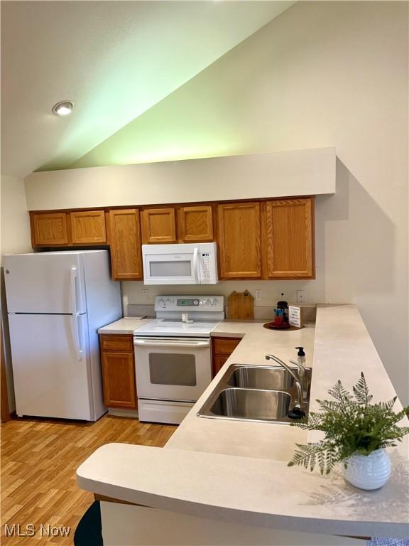 1932 S Lincoln Ave Unit 2, Salem, OH 44460 - kitchen featuring white appliances, a sink, brown cabinets, light countertops, and lofted ceiling