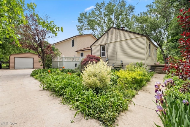 view of property exterior featuring a garage and an outdoor structure