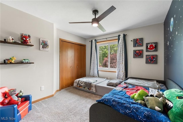 carpeted bedroom featuring a closet, baseboards, and ceiling fan