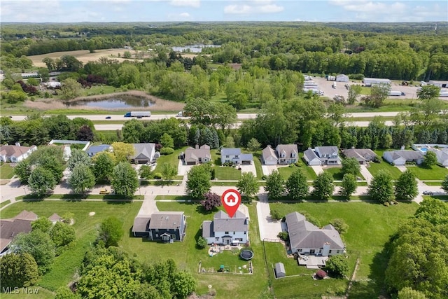 aerial perspective of suburban area with a large body of water and a heavily wooded area