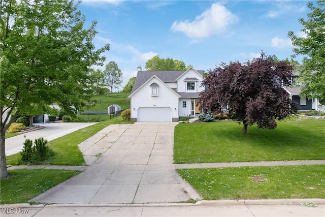 traditional home with concrete driveway, a front lawn, an attached garage, and a chimney