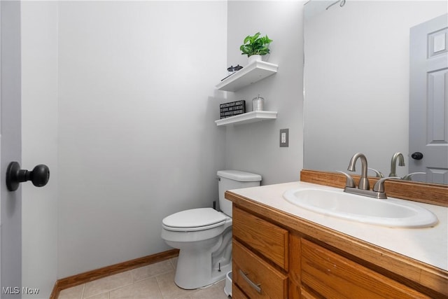 bathroom featuring toilet, vanity, tile patterned floors, and baseboards