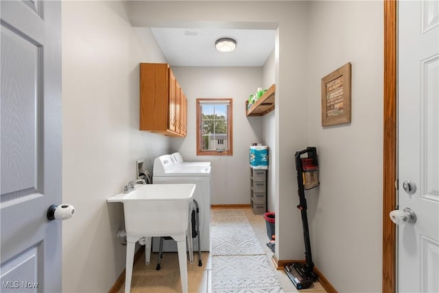 washroom with independent washer and dryer, cabinet space, baseboards, and light tile patterned floors