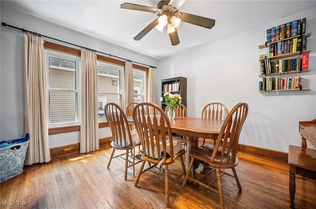 dining room featuring hardwood / wood-style floors, baseboards, and a ceiling fan