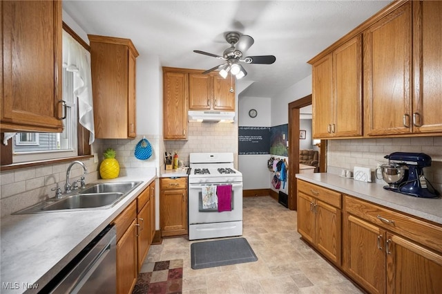 kitchen featuring white gas range, a sink, dishwasher, under cabinet range hood, and brown cabinets