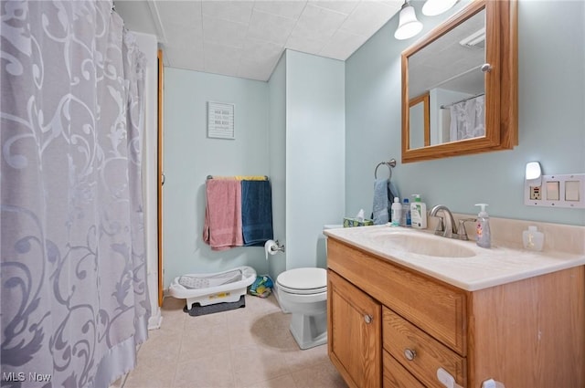 bathroom featuring toilet, vanity, tile patterned floors, and a shower with shower curtain