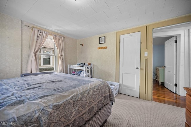 carpeted bedroom with wood finished floors
