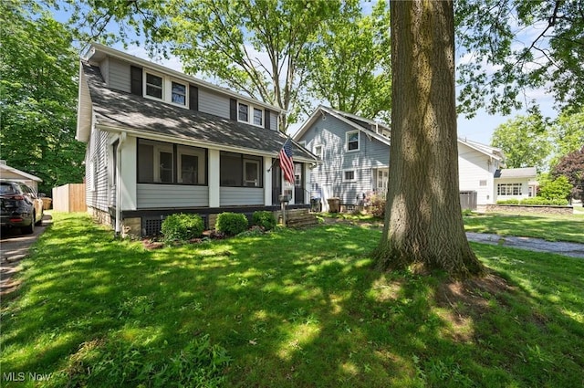view of front of property featuring a front lawn and a shingled roof
