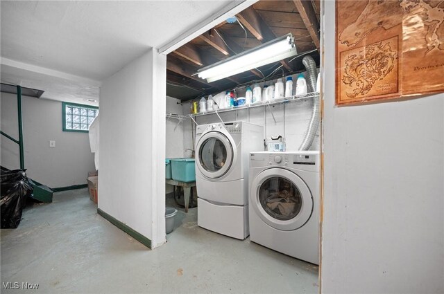 laundry area with washing machine and clothes dryer and baseboards