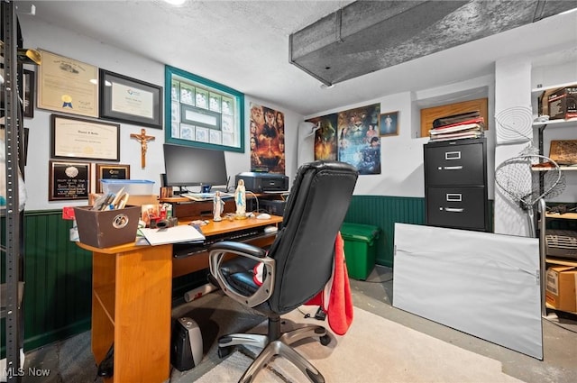 home office featuring wainscoting and a textured ceiling
