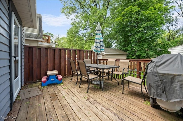 deck with outdoor dining area and a fenced backyard