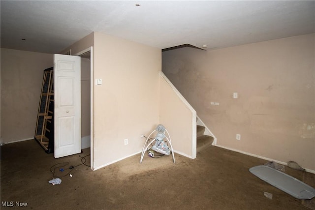 basement with baseboards, carpet flooring, and stairway