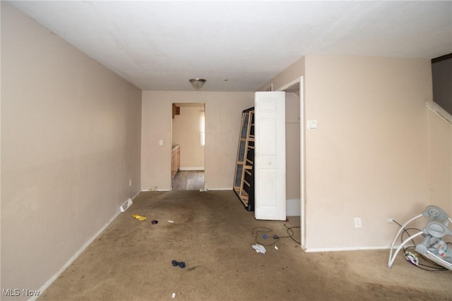 spare room featuring carpet and baseboards