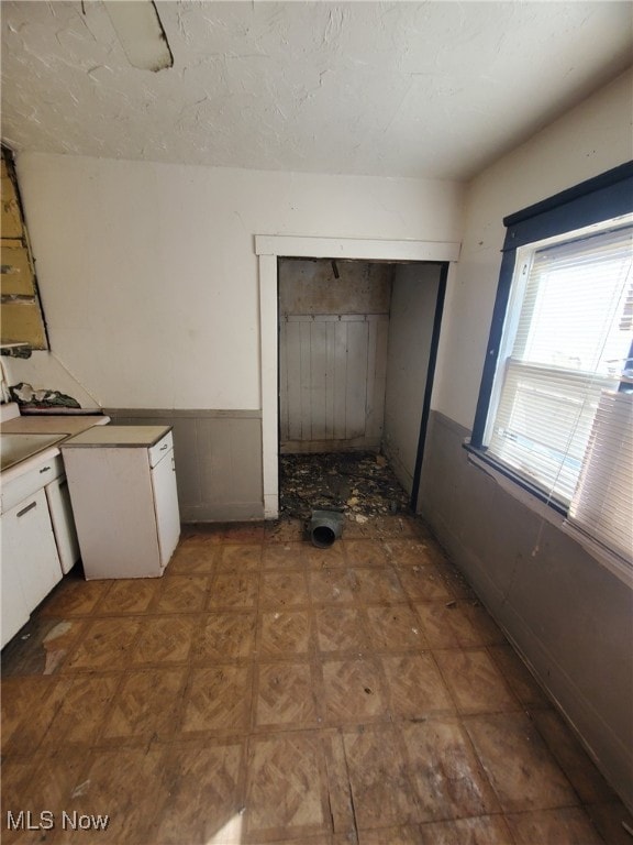 1239 E 143rd St, East Cleveland, OH 44112 - kitchen featuring wainscoting and white cabinets