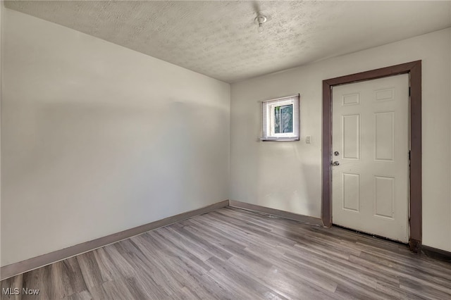 2212 Randall St, Lorain, OH 44052 - unfurnished room with wood finished floors, baseboards, and a textured ceiling