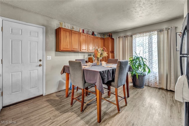 2212 Randall St, Lorain, OH 44052 - dining room with light wood-style flooring, a textured ceiling, and baseboards