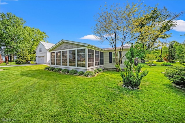 7214 Ridge Ave, Conneaut, OH 44030 - back of property with a sunroom, a lawn, and a garage