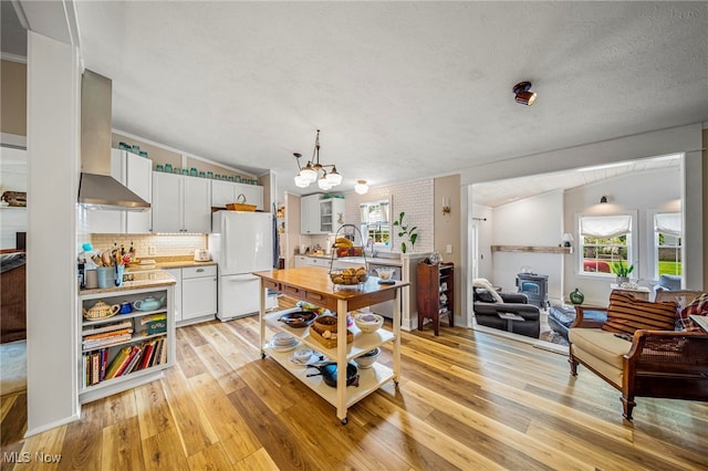 7214 Ridge Ave, Conneaut, OH 44030 - kitchen featuring freestanding refrigerator, plenty of natural light, light wood finished floors, a chandelier, and vaulted ceiling