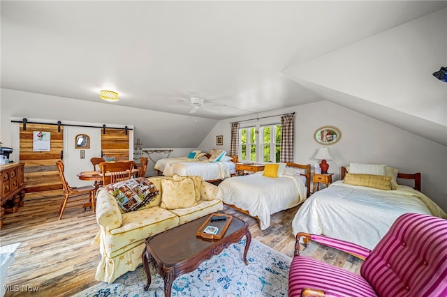 7214 Ridge Ave, Conneaut, OH 44030 - bedroom featuring wood finished floors, lofted ceiling, a barn door, and a ceiling fan