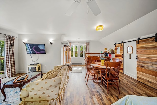7214 Ridge Ave, Conneaut, OH 44030 - dining space with wood finished floors, ceiling fan, a barn door, a baseboard heating unit, and baseboards