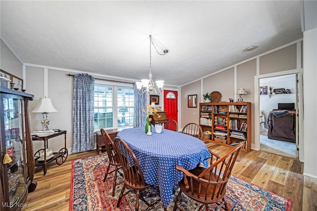 7214 Ridge Ave, Conneaut, OH 44030 - dining room with a chandelier, light wood-type flooring, and crown molding