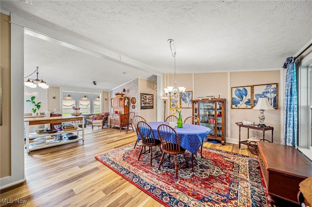 7214 Ridge Ave, Conneaut, OH 44030 - dining area featuring a chandelier, wood finished floors, and a textured ceiling