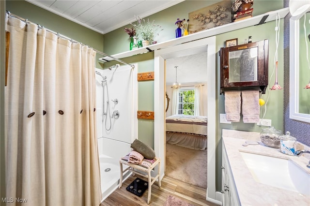 7214 Ridge Ave, Conneaut, OH 44030 - ensuite bathroom with wood finished floors, a shower with shower curtain, vanity, and ornamental molding