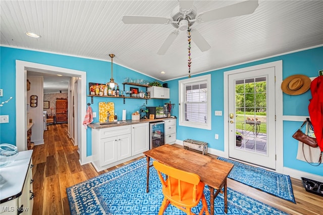 7214 Ridge Ave, Conneaut, OH 44030 - dining room featuring bar with sink, wine cooler, light wood finished floors, vaulted ceiling, and a ceiling fan