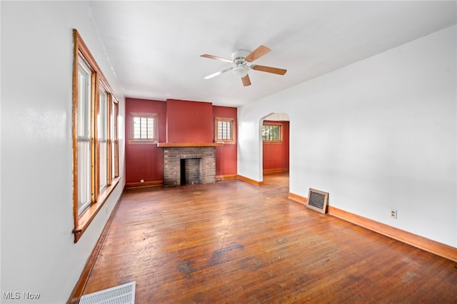 494 W Columbia St, Alliance, OH 44601 - unfurnished living room with baseboards, a fireplace, a ceiling fan, and wood-type flooring