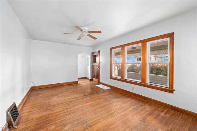 494 W Columbia St, Alliance, OH 44601 - spare room featuring baseboards, arched walkways, wood finished floors, and a ceiling fan