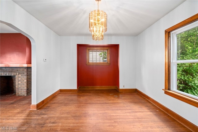 494 W Columbia St, Alliance, OH 44601 - foyer entrance with wood finished floors, a chandelier, a brick fireplace, and baseboards