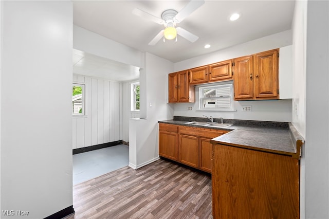 494 W Columbia St, Alliance, OH 44601 - kitchen featuring a sink, dark countertops, wood finished floors, brown cabinetry, and recessed lighting