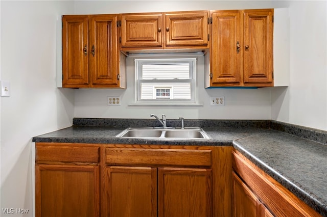 494 W Columbia St, Alliance, OH 44601 - kitchen featuring a sink, dark countertops, and brown cabinetry