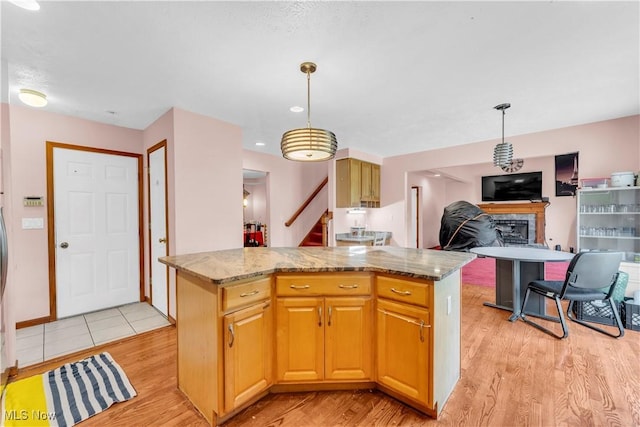 2736 Green Rd, Shaker Heights, OH 44122 - kitchen featuring light wood-style floors, a fireplace, light stone countertops, and pendant lighting