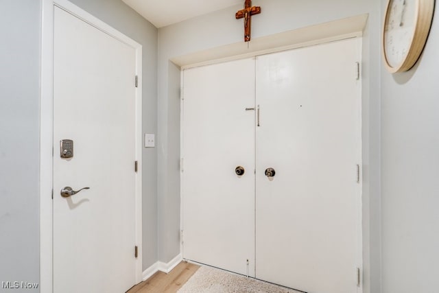 hallway with light wood-style floors and baseboards