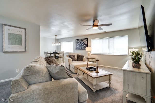 carpeted living room featuring ceiling fan and baseboards