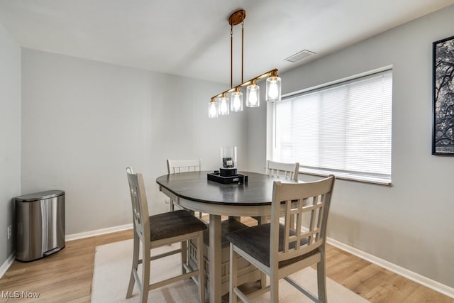 dining room featuring light wood-type flooring and baseboards