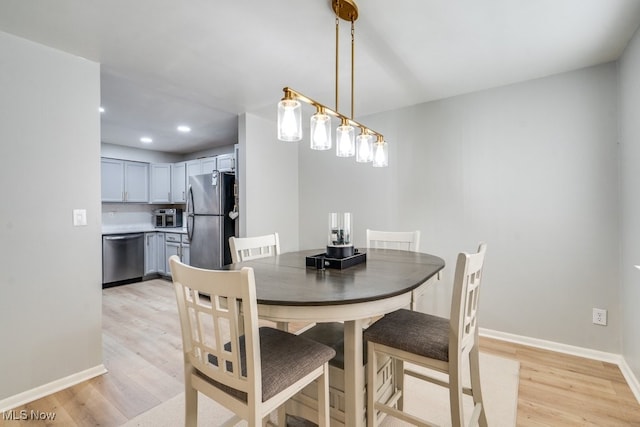dining room featuring light wood-style flooring, recessed lighting, and baseboards