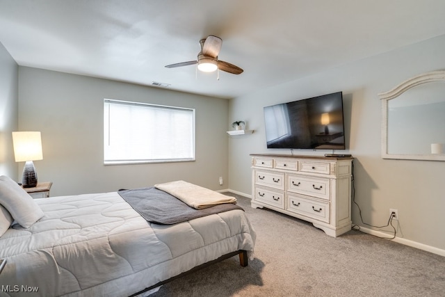 bedroom featuring light colored carpet, baseboards, and ceiling fan