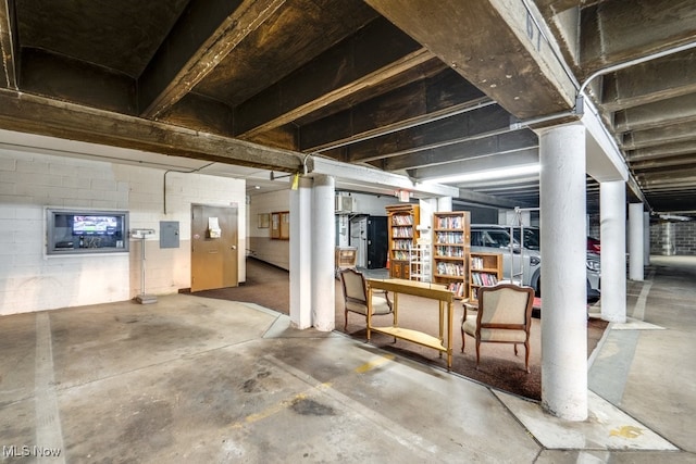 basement featuring electric panel and concrete block wall