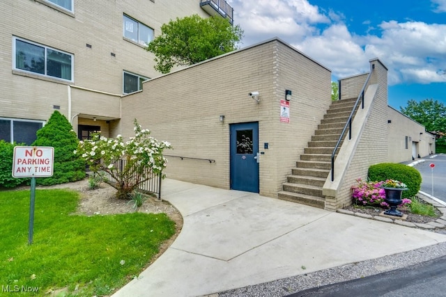 view of building exterior featuring concrete driveway, stairway, and a garage