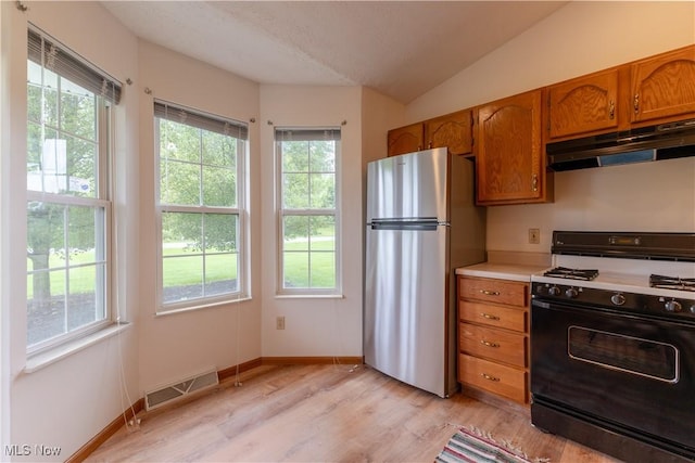 6957 Tippecanoe Rd, Canfield, OH 44406 - kitchen featuring gas stove, freestanding refrigerator, under cabinet range hood, brown cabinetry, and light countertops