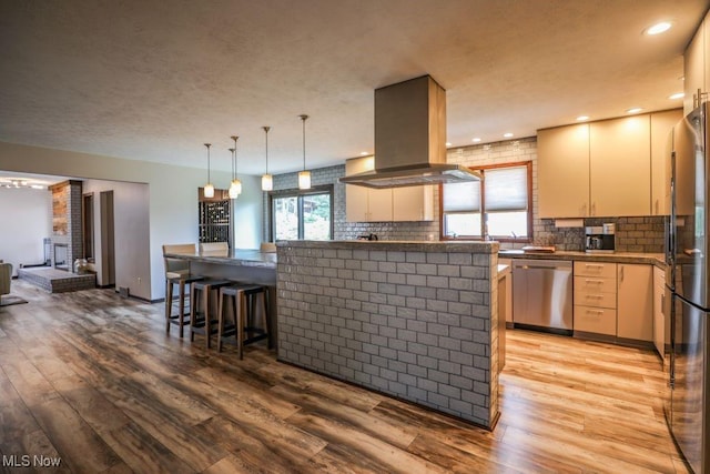 1367 Mockingbird Dr, Kent, OH 44240 - kitchen with stainless steel appliances, island exhaust hood, light wood finished floors, tasteful backsplash, and recessed lighting