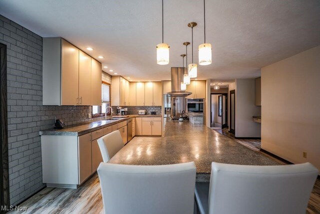 1367 Mockingbird Dr, Kent, OH 44240 - kitchen featuring appliances with stainless steel finishes, dark countertops, a kitchen island, backsplash, and recessed lighting