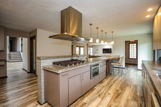 1367 Mockingbird Dr, Kent, OH 44240 - kitchen featuring island range hood, stainless steel appliances, light wood-style floors, decorative light fixtures, and recessed lighting