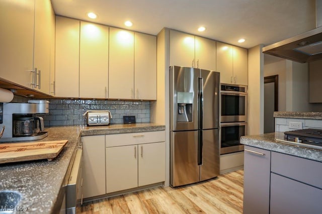 1367 Mockingbird Dr, Kent, OH 44240 - kitchen with appliances with stainless steel finishes, light wood-style floors, backsplash, range hood, and dark countertops